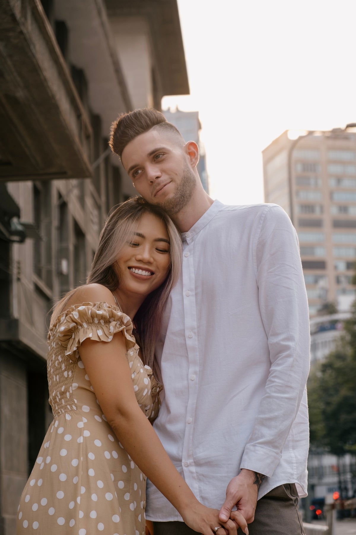 Man and woman embracing on a sunlit city street