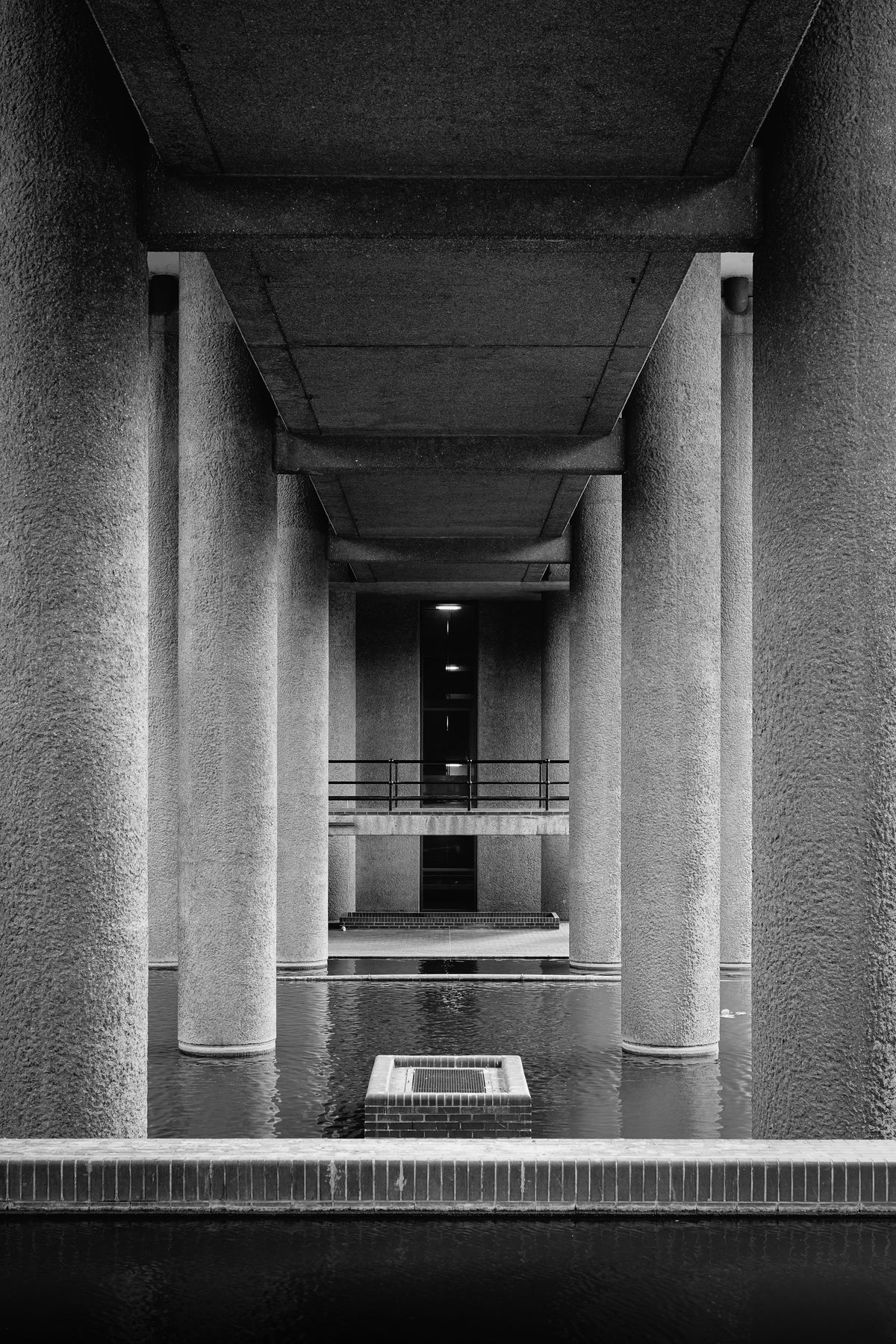 Monochrome concrete columns and reflecting water at London's Barbican
